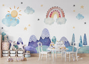 Watercolor kids' room mural with pastel mountains, a rainbow, a sun, clouds, and stars for a dreamy, playful atmosphere.