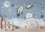 Space-themed wall mural with rocket, UFOs, planets, and constellations on a blue sky background—ideal for kids' room décor.