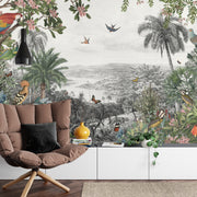Vintage tropical wall mural with lush greenery, exotic birds, butterflies, and palm trees set against a black-and-white scenic landscape.