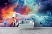 Celestial Dreams galaxy wall mural with colorful nebula clouds in orange, blue, and purple tones, styled in a bright room with a modern bench and lamp.
