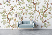 Nature-inspired floral and bird wall mural featuring blooming flowers, branches, birds, and butterflies in a living room setting.