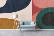 Earthy geometric wall mural with abstract curved shapes in green, ochre, navy, and blush, creating a modern and minimalist bedroom atmosphere.