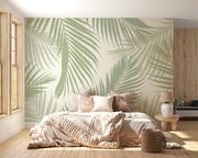 Serene palm leaf wall mural with soft green overlapping leaves on a neutral background, styled in a modern bedroom with wooden accents.