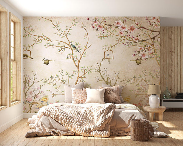 Elegant bedroom interior featuring a pastel Chinoiserie wall mural with delicate cherry blossoms and birds, complemented by neutral boho bedding and soft lighting.