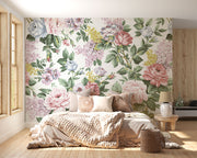 Elegant vintage floral wall mural with pink roses, lilacs, and greenery behind, decorating a bedroom.
