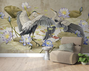 A sophisticated living room featuring an Elegant Heron & Lotus Pond Wall Mural with elegant birds in mid-flight, soft-toned lotus flowers, and floating lily pads. A neutral-colored linen chair, and decorative accents complete the serene, nature-inspired ambiance.