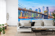 New York City Brooklyn Bridge wall mural featuring the Manhattan skyline at twilight in a modern living room with white decor.