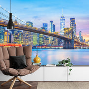 New York City Brooklyn Bridge wall mural featuring the Manhattan skyline at twilight in a modern living room with white decor.