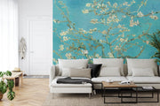 Wall mural of almond blossoms on a turquoise background, inspired by classic artwork, enhancing a modern living room with artistic elegance.