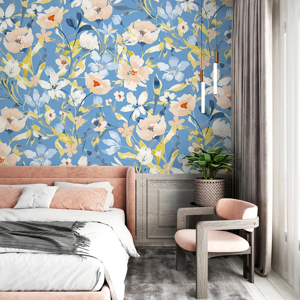 Bold botanical wall mural with vibrant blue, beige, and yellow flowers, styled in a bedroom.