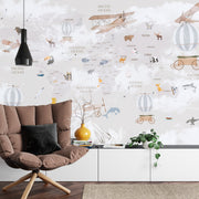 Whimsical world map wall mural featuring illustrated continents, animals, vintage airplanes, and hot air balloons, styled in a modern kids' room.
