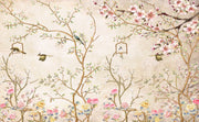 Elegant bedroom interior featuring a pastel Chinoiserie wall mural with delicate cherry blossoms and birds, complemented by neutral boho bedding and soft lighting.