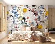 Bedroom with floral wallpaper and decorative pillows on a bed.