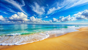 Serene beach wall mural featuring turquoise ocean waves, golden sand and a blue sky with fluffy clouds.