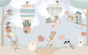 Nursery wall mural with pastel-colored forest animals flying in hot air balloons, surrounded by trees, clouds, and heart-shaped balloons
