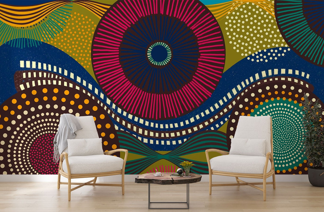 Vibrant abstract wall mural with bold geometric circular patterns, featuring bright colors and dynamic designs for modern interior decor. Styled in a living room with two chairs.