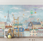 Paris-themed kids’ wall mural with the Eiffel Tower, hot air balloons, colorful rooftops, and kites in soft pastel colors, perfect for a nursery or playroom.