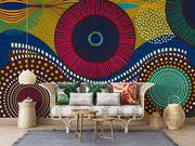 Vibrant abstract wall mural with bold geometric circular patterns, featuring bright colors and dynamic designs for modern interior decor. Styled in a living room with a sofa.