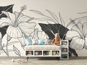 Children’s room with toys and a bench set against a monochrome botanical wallpaper with floral line illustrations.

