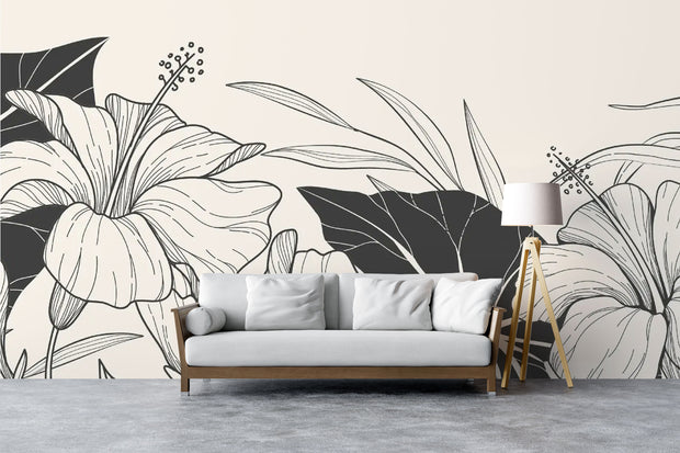 Modern living room with black and white floral wall mural featuring large line-art hibiscus flowers and bold leaves.