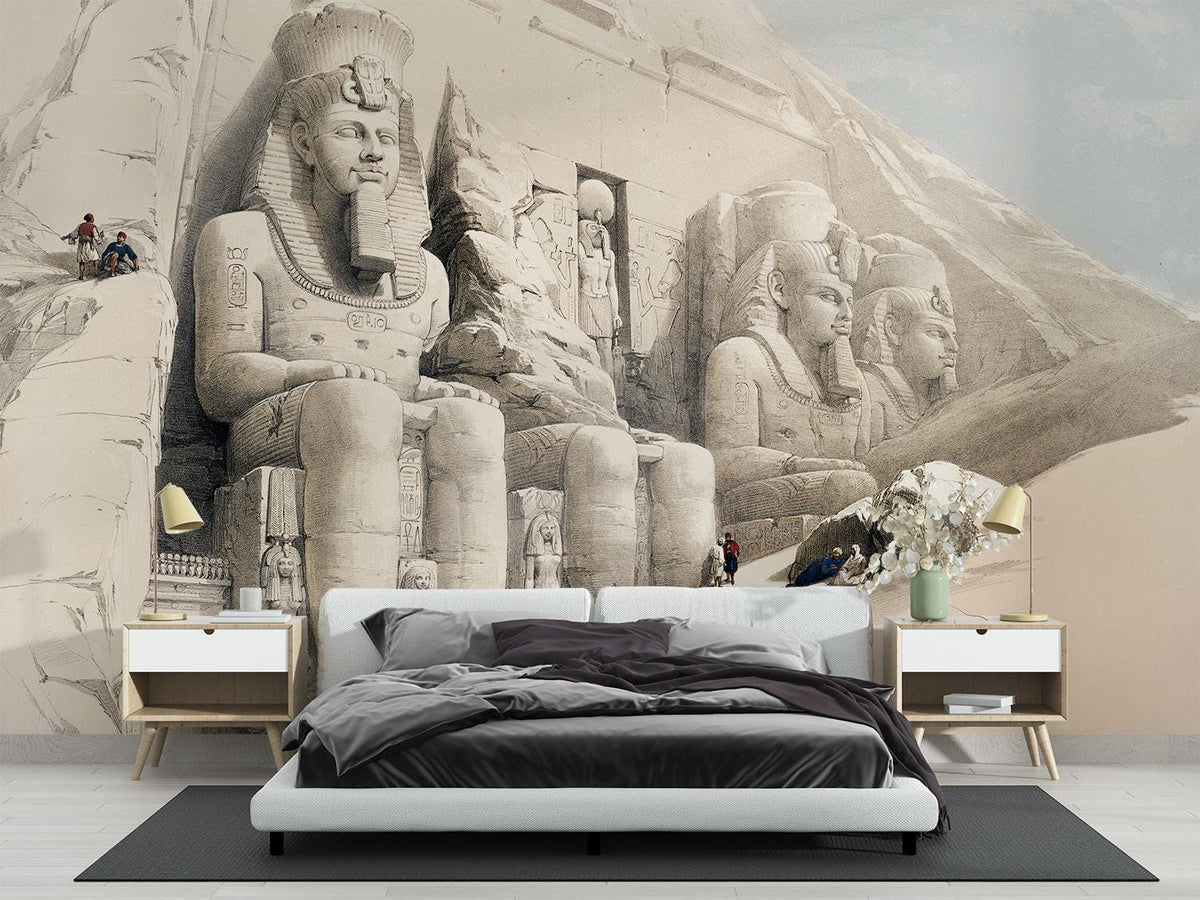 Monumental pharaoh statues and a carved temple in pale desert sand — bedroom with dark bedding mock-up