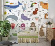 Children's room with crib, colorful animal wallpaper, and wooden dresser.