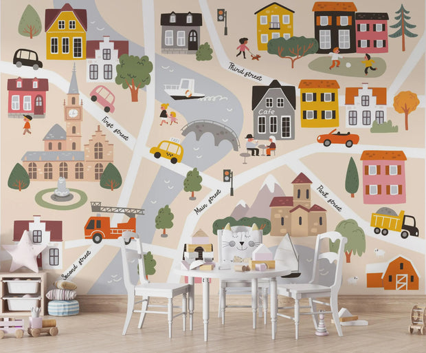 Children's map of a town with colorful houses, roads, and vehicles on a wall.