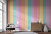 Living room with a colorful striped wall, gray armchair, wooden cabinet, and decorative items.
