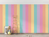 Colorful striped wall with a wooden ladder and decorative items.