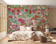 Bedroom with a colorful floral wall mural and wooden flooring.