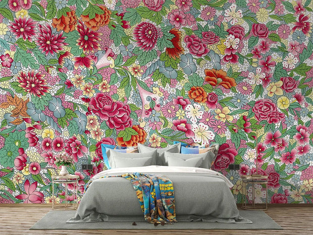 Bedroom with colorful floral wallpaper and a bed with gray bedding and a multicolored throw blanket.