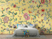 Bedroom with colorful floral wallpaper and a bed with gray bedding.