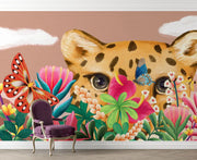 Wall mural with a leopard, butterflies, and flowers on a beige wall.