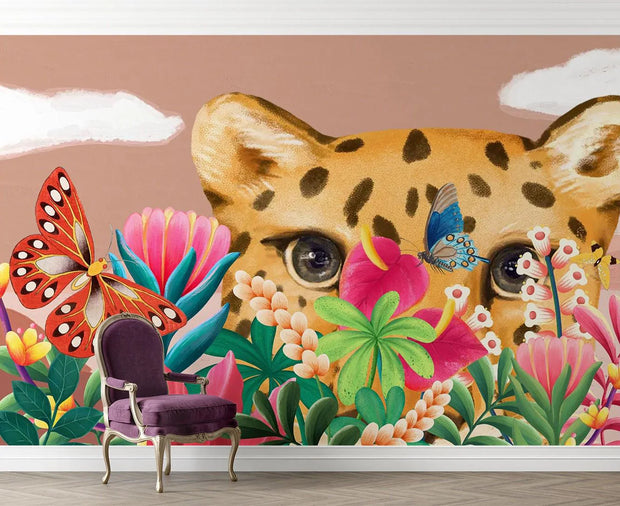Wall mural with a leopard, butterflies, and flowers on a beige wall.