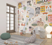 Children's room with colorful wall mural of a town, rug, and toys.