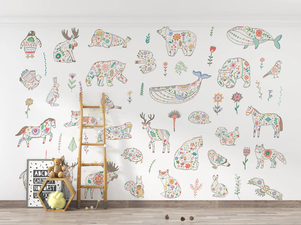 Children's room with floral animal wall decals on a white wall.