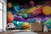 Colorful space-themed mural with planets and stars on a wall, featuring a chair and dresser below.