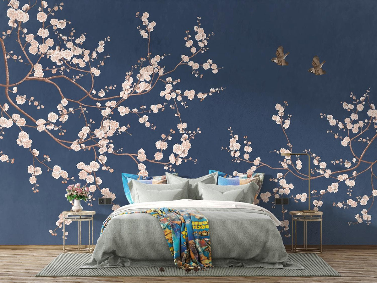 Navy Chinoiserie cherry blossom wall mural with pale pink flowers in a bedroom.
