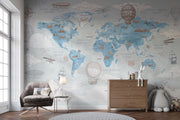 Blue Vintage Travel World Map Wall Mural – nursery with an armchair and chest of drawers mock-up