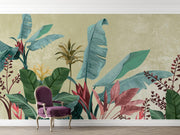 A tropical wall mural featuring large green, teal, and pink palm leaves on a textured beige background, shown in a room setting with a purple velvet armchair and light wood flooring.
