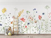 Colorful floral wall decals on a white wall with a wooden ladder and toys below.