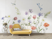 Yellow sofa in front of a wall with floral and dragonfly decorations
