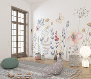 Children's room with floral wall decals, a rug, and decorative pillows.