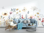 Living room with a blue sofa, wicker chair, and floral wall mural.