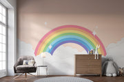 Children's room with a rainbow mural on the wall, a chair, and a dresser.