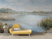 Yellow sofa in a room with a large wall mural of a lake and landscape.