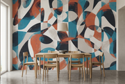 A dining room scene with a wooden table and chairs set against a large abstract wall mural featuring flowing organic shapes in teal, rust orange, navy, cream, and white.