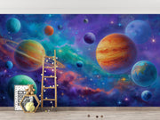 Wall mural of a colorful space scene with planets and a ladder, featuring a teddy bear and alphabet blocks.