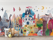 Colorful children's mural with castle, trees, and animals on a white wall.