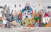 Colorful mural of a fantasy landscape with houses, trees, and animals in a child's room.